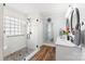 This modern bathroom features a sleek glass shower, stone floor, and double vanity at 801 Toncin Ave, Bessemer City, NC 28016