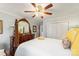 Bright bedroom featuring a ceiling fan, a white bed and an antique wooden dresser with a mirror at 801 Toncin Ave, Bessemer City, NC 28016
