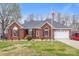 Charming one-story brick home with well-manicured lawn, American flag, and attached two-car garage at 801 Toncin Ave, Bessemer City, NC 28016