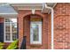 A welcoming front entrance featuring a beautifully decorated glass door and classic brick archway at 801 Toncin Ave, Bessemer City, NC 28016