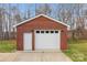 Detached brick garage with white doors and a well-maintained driveway with natural light at 801 Toncin Ave, Bessemer City, NC 28016