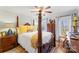 A grand four-poster bed, complemented by bright yellow throw pillows and decorative lamps at 801 Toncin Ave, Bessemer City, NC 28016