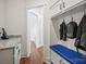 Mudroom with a blue bench, coat hooks, and storage cabinets leading into the home's interior at 8601 Balcony Bridge Rd, Huntersville, NC 28078