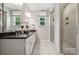 Elegant bathroom features dual sinks with black countertops and a glass enclosed shower with tile surround at 8648 Miles Gap Rd, Indian Land, SC 29707