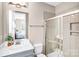 Bright bathroom with white tiled shower, glass door, and a white countertop sink at 967 Stebbins Dr, Fort Mill, SC 29715