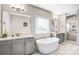 Bright bathroom featuring a standalone tub, double vanity, and walk-in shower with glass door at 967 Stebbins Dr, Fort Mill, SC 29715