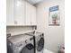 Well-lit laundry room featuring a washer, dryer, and upper cabinets for storage at 967 Stebbins Dr, Fort Mill, SC 29715