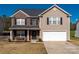 Charming two-story home featuring a brick facade, attached two-car garage and manicured front lawn at 1017 Village Green Ln, Rock Hill, SC 29730