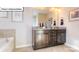 Bathroom featuring double vanity with granite countertop, dark cabinets and decorative mirror at 1049 Merganser Way, Indian Trail, NC 28079