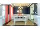 Elegant dining room featuring dark blue walls, wainscoting, stylish lighting, and a view to the Kitchen at 1049 Merganser Way, Indian Trail, NC 28079
