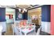 Elegant dining room featuring dark blue walls, wainscoting, stylish lighting, and a view to the Kitchen and Foyer at 1049 Merganser Way, Indian Trail, NC 28079