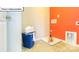 Functional laundry room with orange accent wall, storage, and tiled floor at 1049 Merganser Way, Indian Trail, NC 28079