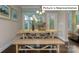 Cozy dining area with wood floors, a farmhouse-style table, and natural light from the windows at 1051 Merganser Way, Indian Trail, NC 28079