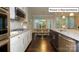 Open kitchen with white cabinets, granite counters, stainless appliances, and dark wood floors at 1051 Merganser Way, Indian Trail, NC 28079