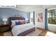 Stylish main bedroom with a tufted headboard, decorative pillows, and large windows for ample natural light at 1055 Merganser Way, Indian Trail, NC 28079