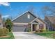 Charming home features a gray facade, stone accents, and a well-manicured lawn at 1128 Avalon Pl, Matthews, NC 28104