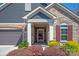 Inviting entryway with stone details, colorful landscaping, and covered porch at 1128 Avalon Pl, Matthews, NC 28104
