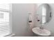 Stylish bathroom with a modern pedestal sink, framed mirror, and bright natural light at 141 Slip Shot Ln, Troutman, NC 28166