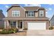 Charming two-story home boasts stone accents, neutral siding, a two-car garage and a welcoming front porch at 141 Slip Shot Ln, Troutman, NC 28166