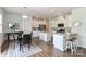 Open floorplan kitchen and dining area with granite counters, white cabinets, stainless steel appliances, and wood floors at 141 Slip Shot Ln, Troutman, NC 28166