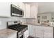 Kitchen with stainless steel gas range, appliances, white cabinets, and granite counters at 141 Slip Shot Ln, Troutman, NC 28166