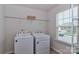 Functional laundry room with a washer, dryer, shelving, and natural light offering convenience and efficiency at 141 Slip Shot Ln, Troutman, NC 28166