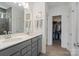 Bright bathroom features a double vanity with gray cabinets and a walk-in closet at 14235 Canemeadow Dr # 102, Charlotte, NC 28278