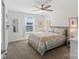 Bright and spacious bedroom with a ceiling fan, natural lighting, and floral comforter at 14235 Canemeadow Dr # 102, Charlotte, NC 28278