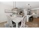 Cozy dining area featuring a white dining table, designer lighting, and views into the modern kitchen at 14235 Canemeadow Dr # 102, Charlotte, NC 28278