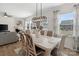 Elegant dining room with a modern chandelier, white table, and views into the living area and backyard at 14235 Canemeadow Dr # 102, Charlotte, NC 28278