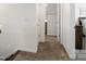 Bright carpeted hallway with white trim and walls, leading to various rooms at 14235 Canemeadow Dr # 102, Charlotte, NC 28278