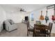 Open living area with neutral decor, modern furnishings, and a dining space with hanging guitars at 14235 Canemeadow Dr # 102, Charlotte, NC 28278