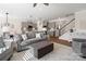 Bright open-concept living room featuring modern gray furniture and hardwood floors, adjacent to a stylish kitchen at 14235 Canemeadow Dr # 102, Charlotte, NC 28278