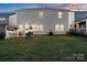 Back exterior of home featuring a spacious green yard, patio area with furniture, grill and fence perimeter at 14235 Canemeadow Dr, Charlotte, NC 28278