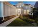 Inviting home exterior features a walkway leading to the front door, complemented by manicured landscaping and soft outdoor lighting at 14235 Canemeadow Dr, Charlotte, NC 28278