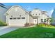 Beautiful home exterior featuring an attached garage, a manicured lawn and pathway to the front door entrance at 14235 Canemeadow Dr, Charlotte, NC 28278