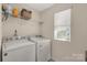 Well-lit laundry room with modern washer and dryer units and functional shelving at 1519 Arcadia Bluff Dr, York, SC 29745