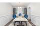 Formal dining room featuring elegant wainscoting, stylish curtains, modern chandelier, and a dining set for six at 16200 Winfield Hall Dr, Charlotte, NC 28273