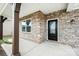 Inviting front porch with stone accents, dark wood columns and a modern black front door at 16200 Winfield Hall Dr, Charlotte, NC 28273