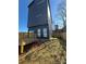 Backyard with a small wooden deck, minimal grass, and a tall gray home exterior at 211 S Webb St, Gastonia, NC 28052