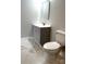 Bathroom with gray vanity and toilet on marble-patterned tile flooring at 211 S Webb St, Gastonia, NC 28052