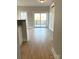 Bright living room featuring wood floors, a sliding glass door to the deck, and light gray walls at 211 S Webb St, Gastonia, NC 28052