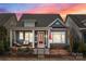 Charming two-story home featuring a welcoming front porch with comfortable seating and a beautiful dusk sky backdrop at 21812 Chapel Way # 20, Cornelius, NC 28031