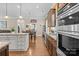Spacious kitchen showcasing an island with granite countertops, stainless steel appliances, and hardwood floors at 21812 Chapel Way # 20, Cornelius, NC 28031