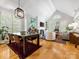 Open-concept living room with a vaulted ceiling, fireplace, and large windows for plenty of natural light at 2310 Roswell Ave # H, Charlotte, NC 28207