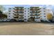 Multi-level condo building featuring private balconies and a well-maintained parking lot at 2503 Roswell Ave # 208, Charlotte, NC 28209