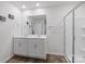 Bright bathroom featuring double sinks and a large shower with glass doors, a large mirror and wood-look floors at 2766 Sherrills Stream Dr, Sherrills Ford, NC 28673