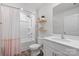 Bright bathroom featuring a single sink vanity and a shower/tub with a shower curtain and wood-look floors at 2766 Sherrills Stream Dr, Sherrills Ford, NC 28673