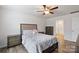 This bedroom features wood-look floors, a ceiling fan, a comfortable bed, and a view into the attached bathroom at 2766 Sherrills Stream Dr, Sherrills Ford, NC 28673