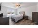 This bedroom features a ceiling fan, a comfortable bed, wood-look floors, and natural light from the window at 2766 Sherrills Stream Dr, Sherrills Ford, NC 28673
